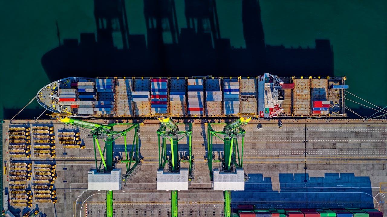 Home High angle aerial view of a cargo ship at a bustling port in Jakarta, showcasing global trade.